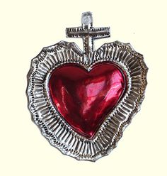 a red heart in a silver frame with a cross