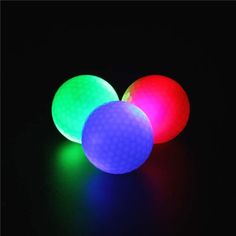 three glowing balls on a black surface with the light reflecting off it's sides