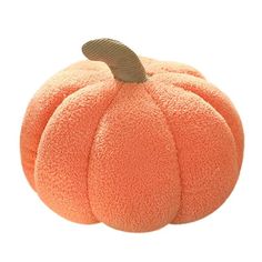 an orange stuffed pumpkin sitting on top of a white surface