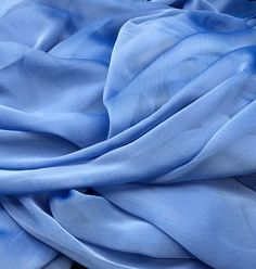 the blue fabric is laying on top of each other in close up view, it appears to be very soft