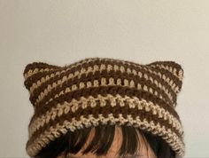 a close up of a person wearing a knitted hat with a cat's head on top