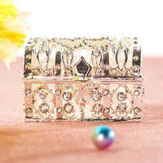 a close up of two different types of jewelry on a pink surface with flowers in the background