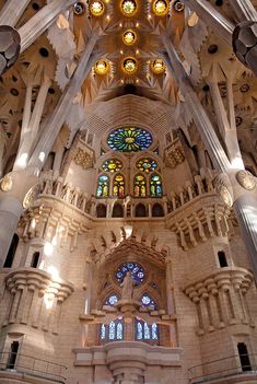 the interior of a large cathedral with stained glass windows and columns on each side of the ceiling