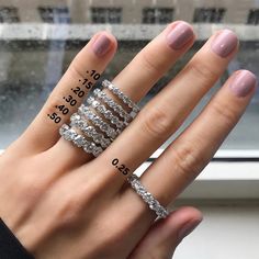 a woman's hand with five different rings on her fingers and the words ring size