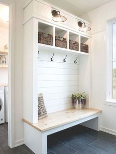 a white bench with baskets on it in front of a washer and dryer