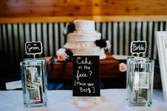 a table topped with two vases filled with money next to a sign that says bride in the lead?