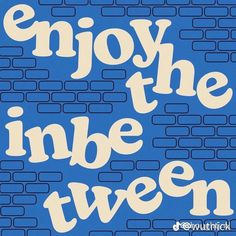 the words enjoy the inner twon are in white letters on a blue brick wall