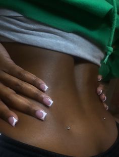 a woman's stomach with white and pink nail polishes on her tummy