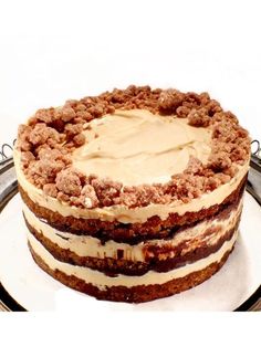 a cake with white frosting and crumbs on top is sitting on a plate