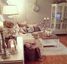 a living room filled with lots of furniture and candles on top of it's tables