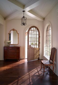 the sun shines through two arched windows in this entryway