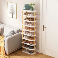 a living room filled with furniture and a white couch in front of a wall mounted shoe rack