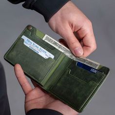 a person holding an empty wallet in their left hand, with money sticking out of it