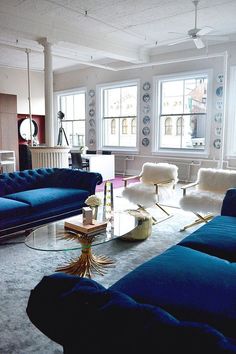 a living room filled with blue couches and chairs