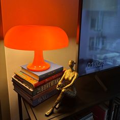 a lamp sitting on top of a table next to books