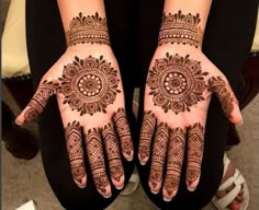 two hands with henna tattoos on them