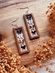 the earrings are made out of wood and decorated with butterflies