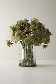 a vase filled with lots of flowers on top of a table