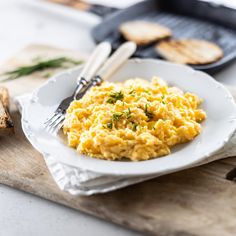 scrambled eggs on a white plate with toast