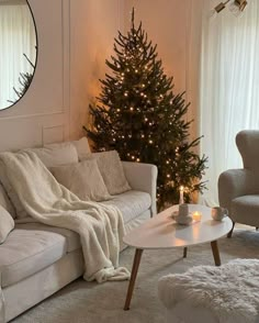 a living room with a christmas tree in the corner and lights on it's walls