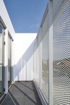 an empty walkway between two white buildings