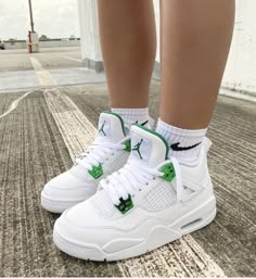 a person wearing white and green sneakers on the street