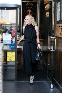 a woman is walking out of a restaurant