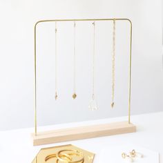 a gold jewelry display on a white table with two pairs of rings and one pair of earrings