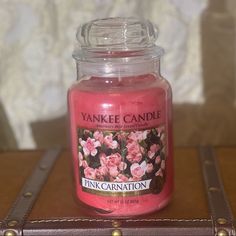 a pink candle sitting on top of a wooden table