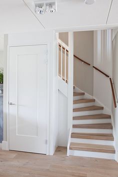 an empty living room with stairs leading up to the second floor and another door on the other side