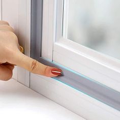 a woman's hand is touching the side of a window with her thumb on it