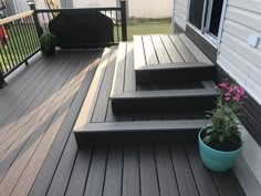 a potted plant sitting on top of a wooden deck next to steps and railing