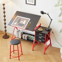 a desk with a chair, lamp and pictures on it