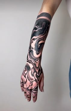 a person with a tattoo on their arm and hand holding something in the other hand