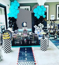 a room filled with balloons and pictures on the wall next to a table covered in black and white checkered paper