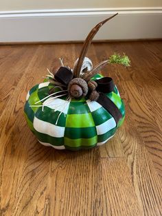 a green and white pumpkin sitting on top of a wooden floor