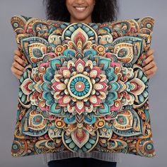 a woman holding up a pillow with an intricate design on it