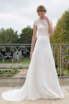 a woman in a wedding dress standing on a balcony