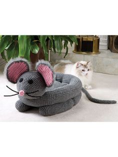 there is a crocheted mouse on the ground next to a cat