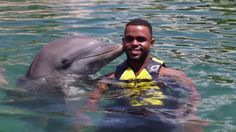 a man is in the water with a dolphin and he has his face close to him