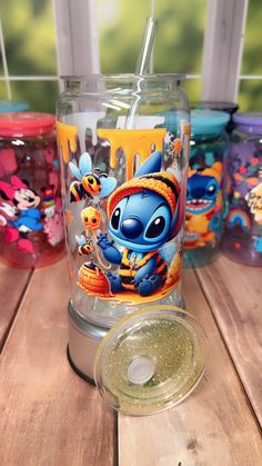 there are many cups on the table and one has an image of stitch - it