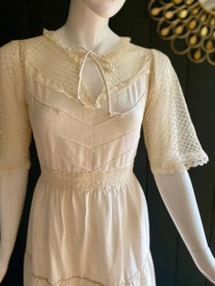 a mannequin wearing a white dress in front of a mirror