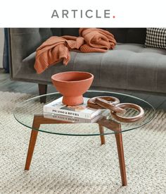 a coffee table that has some books on it and a vase sitting on top of it