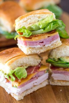 four sandwiches stacked on top of each other with lettuce and ham in the middle