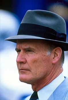 an older man wearing a suit and tie with a hat on top of his head