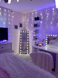 a bedroom decorated in white and purple with lights