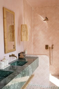 a bathroom with pink walls and marble counter tops