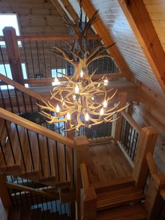 a chandelier hanging from the side of a wooden staircase