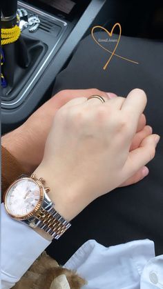 a person holding onto a watch while sitting in a car