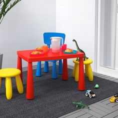 children's plastic table and chairs with toys on the floor in front of them